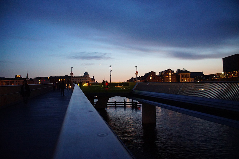 新港旁步行橋上風光。哥本哈根晚霞天空很美，天色也轉瞬黑了下來，於是我們漫步回家。