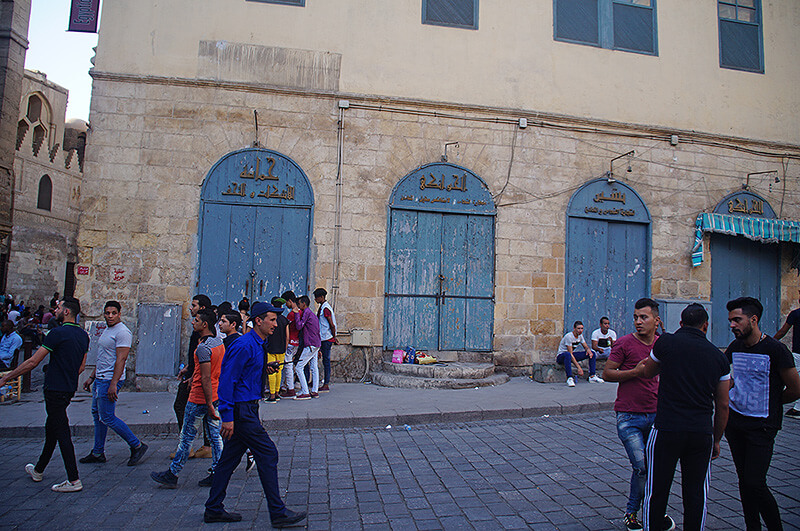 衣著鮮豔的埃及人，三五成群，藍色大門搭配米色磚牆，也頗好看的！