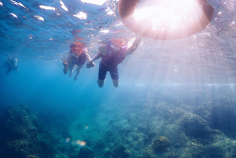 浮潛，穿著救生衣飄在海面上，帶著面鏡往下看海底世界。(泰國，芭達雅，2019)