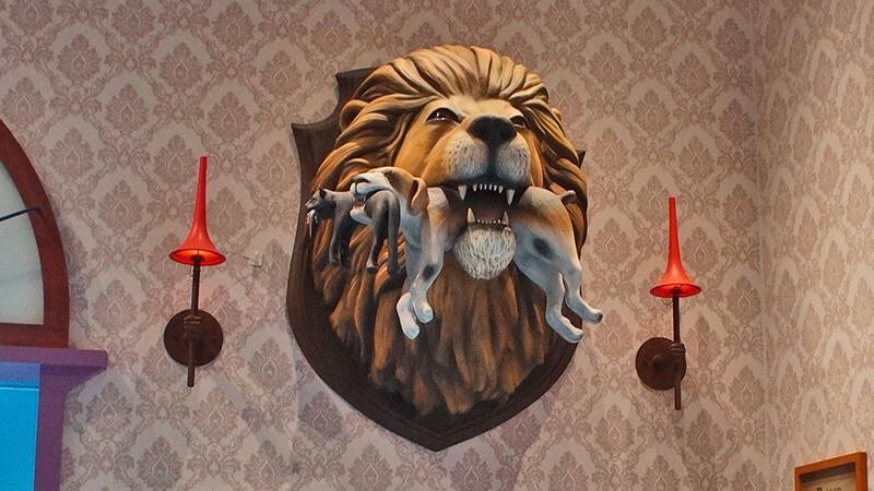 牆壁上，獅子咬著狗咬著貓叼著老鼠。