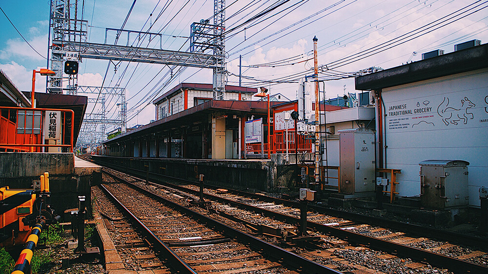 伏見稻荷車站月台，鐵軌，藍天白雲。